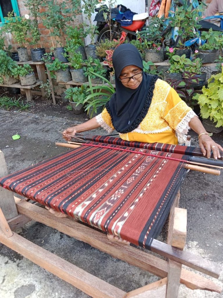 Ibu penenun sedang membuat kain tenun dari NTT